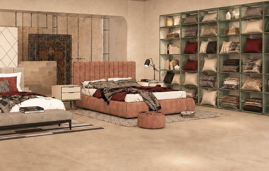 A bedroom setting with an upholstered bed, layered bedding and a wall of folded textiles.